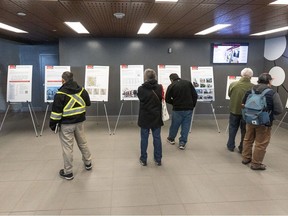 Members of the public look over poster boards outlining the City of Calgary's proposed blanket rezoning plan at city hall on the day of a public hearing into the plan on Monday, April 22, 2024.