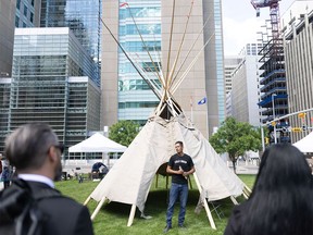 Garret Smith, a member of the Kainai and Piikani Blackfoot Nations, speaks after helping erect a tipi at the opening for the Indigenous Justice Centre Society in downtown Calgary on Monday, June 17, 2024.