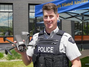RCMP Const. Anthony Setlack shows off a drone outside the Cochrane detachment on Friday.