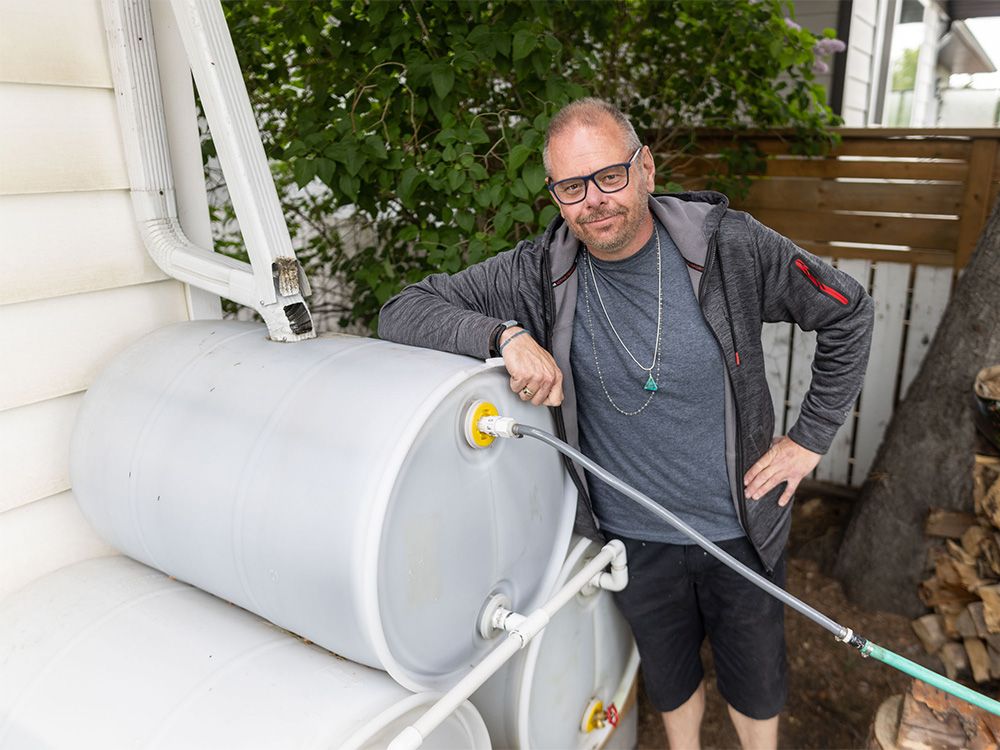 Ron Leitch shows off his water barrel set up behind his home in Calgary on Sunday, June 16, 2024.
