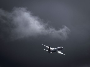 A Boeing 737 plane flies as a storm. Photographer: David Gray/AFP/Getty Images