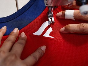 In this handout provided by Fanatics, a Fanatics logo is sewn on the back of a Florida Panthers NHL hockey jersey at the SP Apparel factory in Saint-Hyacinthe, Quebec, Tuesday, June 11, 2024. The NHL unveils new player jerseys for the 2024-25 season made by Fanatics, Wednesday, June 26, 2024, the first time the company has designed and manufactured on-ice/field/court uniforms for a major professional sports league. (Photo courtesy Fanatics via AP)