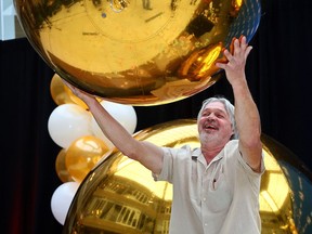 Calgary construction worker James Jutzi collects his $66-million Western Canada Gold Ball jackpot on Wednesday.