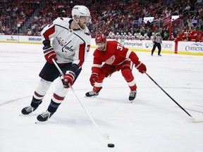 Washington Capitals right wing Anthony Mantha, left, moves the puck against Detroit Red Wings left wing J.T. Compher (37) during the third period of an NHL hockey game Tuesday, Feb. 27, 2024, in Detroit.