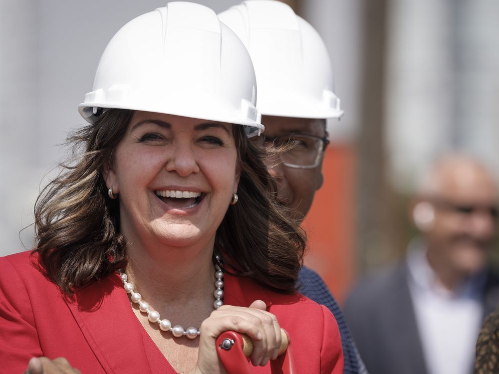 Alberta Premier Danielle Smith leans on a shovel as she prepares to turn the sod on the new Calgary Flames arena in Calgary, Alta., Monday, July 22, 2024.