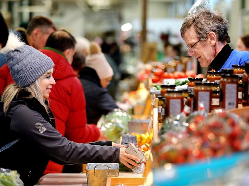 Edmontonians purchase produce at the Doef's Greenhouses booth inside the Old Strathcona Farmers' Market, Saturday Jan. 4, 2025. Alberta's relative affordability is one of the factors driving the province's strong population growth.