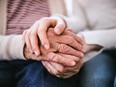 A younger pair of hands holds an older set. It can be difficult discussing estate planning with elderly parents and relatives, especially during holiday get-togethers.