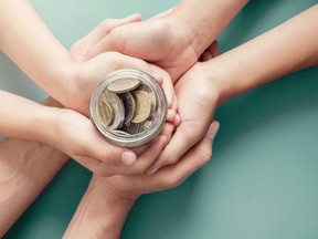 Several hands holding a coin jar. Venture philanthropy can redirect some of the billions of foundation dollars parked in financial markets.