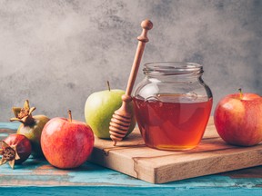 Honey jar and apples on wooden table. Jewish holiday Rosh Hashanah background. As the Jewish High Holiday Rosh Hashanah approaches, three active members of Canada’s Jewish community share how this time of introspection and renewal affects the faith-driven philanthropist.