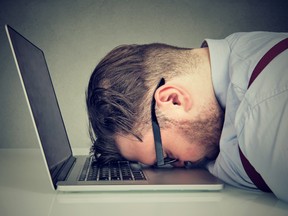 Side view of a man in a suit with his head lying on top of laptop. The C-suite environment is notorious for overworking and prioritizing company demands over their own self-care.