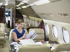 A businesswoman reads documents in a private airplane. There are pros and cons to fractional ownership, but any private aviation includes advantages such as saving time, privacy and flexibility.