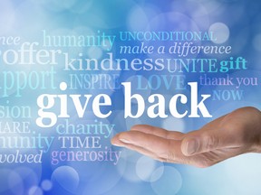 An illustration showing a hand, palm up, with a word cloud with words including "give back," "make a difference," "kindness," "humanity" "inspire," "thank you," "charity," "generosity," "gift."
