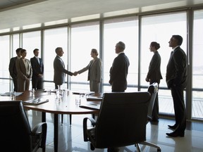 Business people shaking hands in conference room. From letters of intent to cultural integration, getting the many complex details right in an M&A deal takes attention to detail and getting the right experts.