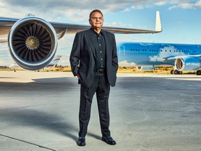 Ajay Virmani, founder and executive chairman of Mississauga, Ont.-based Cargojet Inc., stands next to an airplane wing and engine with planes visible in the background.