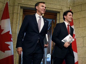 Finance Minister Bill Morneau and Prime Minister Justin Trudeau leave the Prime Minister's office holding copies of the federal budget in Ottawa, Wednesday, March 22, 2017.