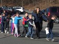In this photo provided by the Newtown Bee, Connecticut State Police lead a line of children from the Sandy Hook Elementary School in Newtown, Conn. on Dec. 14, 2012 after a shooting at the school. (AP Photo/Newtown Bee, Shannon Hicks/File)