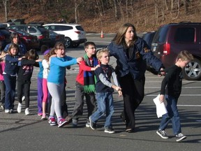 In this photo provided by the Newtown Bee, Connecticut State Police lead a line of children from the Sandy Hook Elementary School in Newtown, Conn. on Friday, Dec. 14, 2012 after a shooting at the school.
 (AP Photo/Newtown Bee, Shannon Hicks, File)