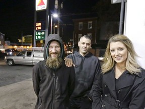 In this Nov. 17, 2017, photo, Johnny Bobbitt Jr., left, Kate McClure, right, and McClure's boyfriend Mark D'Amico pose at a Citgo station in Philadelphia. When McClure ran out of gas, Bobbitt, who is homeless, gave his last $20 to buy gas for her. McClure started a Gofundme.com campaign for Bobbitt that has raised more than $275,000.