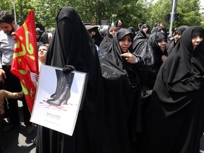 Supporters of Iranian religious hardliners take part in a demonstration after the weekly Friday prayer in Tehran on May 16, 2014 against an ongoing online campaign by Iranian women for greater social freedoms.