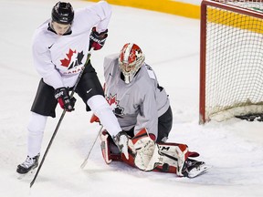 Canadian national junior team goaltending prospect Carter Hart, right, makes a pad save while being screened by forward Cody Glass during selection camp on Dec. 12, 2017