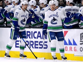 Captain Henrik Sedin of the Vancouver Canucks, right, and his brother Daniel celebrate a goal with their bench. Both are now members of the NHL's 1,000-point club, but their role as mentors is what impresses their younger teammates.