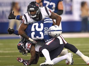 Zach Cunningham #41 and Kareem Jackson #25 of the Houston Texans tackle Frank Gore #23 of the Indianapolis Colts during the second half at Lucas Oil Stadium on December 31, 2017 in Indianapolis, Indiana.