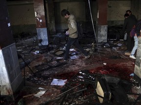 An Afghan boy walks through the the scene of a suicide attack on a Shiite cultural center in Kabul, Afghanistan, Thursday, Dec. 28, 2017.