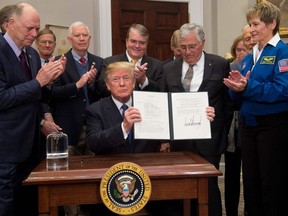 US President Donald Trump signs Space Policy Directive 1, with the aim of returning Americans to the Moon, in the Roosevelt Room at the White House in Washington, DC, December 11, 2017.
