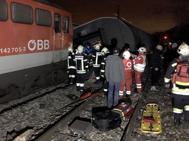 This handout photo made available by the Lower Austrian Fire Department shows members of the emergency services working at the scene when two passenger trains collided causing several carriages to derail in Kritzendorf, Lower Austria on Dec. 22, 2017. (APA AND LOWER AUSTRIAN FIRE DEPARTMENT/AFP/Getty Images/HO)