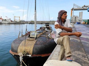 Zbigniew Reket, a Polish sailor who was rescued on December 25 in the Indian Ocean by the French coast guard, sits near his boat in Le Port, on the French overseas island of La Reunion, on December 27, 2017. The French coast guard rescued the 54-year-old Polish sailor in the Indian Ocean who says he spent seven months with only his cat for company in a broken-down boat. Investigators are seeking to piece together the itinerary of the 54-year-old who says he took to the sea in his makeshift vessel from the Comoros Islands off the coast of Mozambique in May with the aim of reaching South Africa.