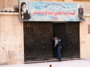 An Egyptian security member inspect the entrance gate of a church south of the capital Cairo, following a gun attack, on December 29, 2017.