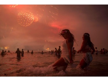People watch fireworks during New Years celebrations at Copacabana beach in Rio de Janeiro on January 1, 2018.