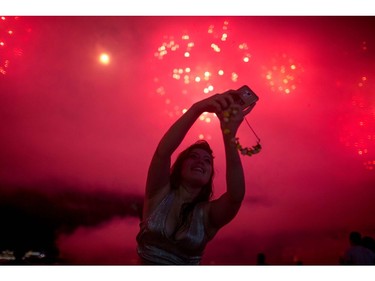 People take photos of fireworks during New Year's celebrations at Copacabana beach in Rio de Janeiro on January 1, 2018.