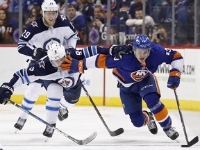 New York Islanders centre Mathew Barzal (13) controls the puck against Winnipeg Jets centre Andrew Copp (9) in the second period, Saturday in New York.