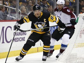 Pittsburgh Penguins' Sidney Crosby (87) works the puck behind the net with Colorado Avalanche's Erik Johnson (6) defending in the second period of an NHL hockey game in Pittsburgh, Monday, Dec. 11, 2017.