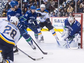 St. Louis Blues' Kyle Brodziak (28) puts a shot off the crossbar behind Vancouver Canucks' goalie Jacob Markstrom, of Sweden, that stays out of the net as Troy Stecher (51) and Markus Granlund (60), of Finland, and St. Louis' Scottie Upshall (9) watch during the first period of an NHL hockey game in Vancouver, on Saturday Dec. 23, 2017. THE CANADIAN PRESS/Darryl Dyck