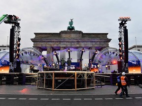 People prepare the stage for New Year's Eve festivities in front of Berlin's landmark Brandenburg Gate on December 30, 2017.
