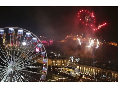 Fireworks light up the sky in Edinburgh in preparation for New Year celebrations, Sunday Dec. 31, 2017. Organisers of Edinburgh's Hogmanay have said the event will go ahead as planned after the city experienced some of the worst weather conditions earlier in the day, with high winds and heavy rain. Prince's Street, where celebrations are set to take place, was temporarily closed to pedestrians in the afternoon due to "weather-related debris". (David Cheskin/PA via AP)