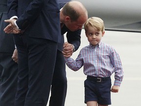 FILE - In this Monday, July 17, 2017 file photo, Britain's Prince William, left, holds the hand of his son Prince George on arrival at the airport, in Warsaw, Poland. A 31-year-old man has been charged in England with sharing a photo of Prince George and details about his pre-school in a social media post prosecutors allege was meant to help others plan terror attacks, it was announced on Wednesday, Dec. 6, 2017. Prosecutors allege Husnain Rashid put the information about the 4-year-old son of Prince William and the former Kate Middleton on the encrypted platform Telegram. Britain's Sun newspaper reports that Rashid allegedly posted the silhouette of an Islamic State fighter beside George.