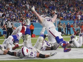 Buffalo Bills defensive tackle Kyle Williams (95) and a group of players fall to the ground in celebration after Williams scored a touchdown, during the second half of an NFL football game against the Miami Dolphins, Sunday, Dec. 31, 2017, in Miami Gardens, Fla.