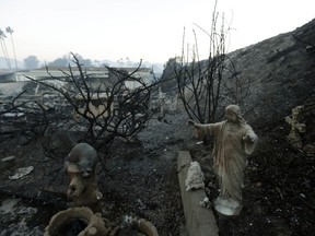 A statue sits among destroyed homes in the Rancho Monserate Country Club community Friday, Dec. 8, 2017, in Fallbrook, Calif. The wind-swept blazes have forced tens of thousands of evacuations and destroyed dozens of homes in Southern California.