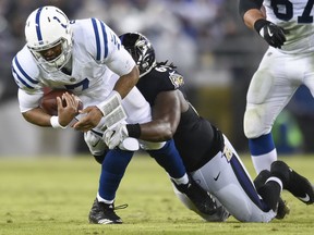 Indianapolis Colts quarterback Jacoby Brissett is sacked by Baltimore Ravens defensive tackle Willie Henry during the first half of an NFL football game in Baltimore, Saturday, Dec 23, 2017. (AP Photo/Gail Burton)