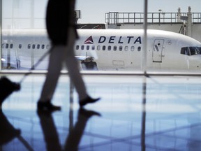 In this Thursday, Oct. 13, 2016, photo, a Delta Air Lines jet sits at a gate at Hartsfield-Jackson Atlanta International Airport in Atlanta.