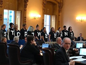 Abortion-rights activists stand in protest on Wednesday, Dec. 13, 2017, in the Ohio Senate chamber in Columbus, after passage of a bill banning abortions in cases of a Down syndrome diagnosis.