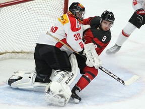 Canada's Dillon Dube crashes into Switzerland goalie Philip Wuthrich on Dec. 22, 2017