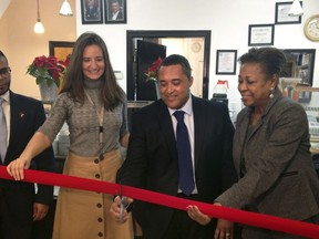 Chef Candido Ortiz, centre, prepares to cut the ceremonial red ribbon opening his restaurant, El Sabor Del Cafe, Tuesday, Dec. 19, 2017 in Jersey City, N.J.
