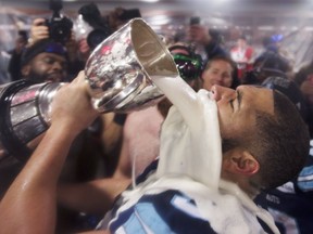 Toronto Argonauts offensive lineman Tyler Holmes quenches his thirst with some suds from the Grey Cup after the Argos’ 27-24 win over the Calgary Stampeders in the CFL’s championship game on Nov. 26, 2017 in Ottawa.