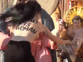 Femen "sextremist" Alisa Vinogradova tries to steal the baby Jesus from the nativity scene in Vatican City in the video screenshot. (Russia Today YouTube Screenshot)