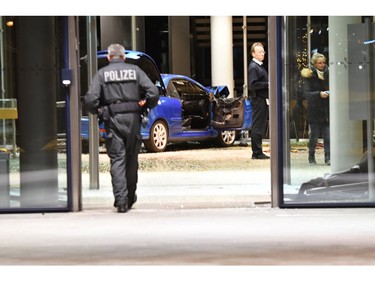 Police standing beside a damaged car in the Social Democratic party, SPD,  headquarters in Berlin, Germany, Monday, Dec. 25, 2017. (Paul Zinken/dpa via AP)