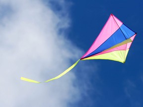 A colourful kite flies in sky in this stock photo.